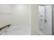 Bright bathroom featuring a soaking tub with a built-in armrest and a separate shower with modern fixtures at 115 Zulabelle Ct, Garner, NC 27529
