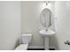 Well-lit half-bathroom featuring a pedestal sink, oval mirror, and tile floors at 115 Zulabelle Ct, Garner, NC 27529