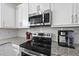 Bright kitchen featuring stainless steel appliances, granite countertops, and white cabinetry at 115 Zulabelle Ct, Garner, NC 27529