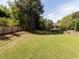Lush backyard with expansive lawn, mature trees, and a wooden privacy fence at 117 Whitehaven Ln, Cary, NC 27519