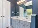 Bathroom featuring a double vanity, large mirror, and blue walls at 117 Whitehaven Ln, Cary, NC 27519