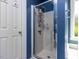 Bathroom shower with glass doors, white tile, and blue walls offers a spa-like experience at 117 Whitehaven Ln, Cary, NC 27519