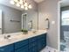 Double sink bathroom with blue vanity and a large mirror offers ample space at 117 Whitehaven Ln, Cary, NC 27519