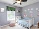 Cozy bedroom with a dinosaur-themed wall, natural light, and ceiling fan at 117 Whitehaven Ln, Cary, NC 27519