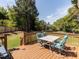 Outdoor seating on wooden deck overlooks a well-maintained backyard with mature trees at 117 Whitehaven Ln, Cary, NC 27519