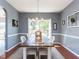 Elegant dining room with modern chandelier, large window, and farmhouse-style table with seating at 117 Whitehaven Ln, Cary, NC 27519
