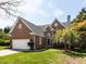 Charming brick home featuring a lush lawn and a two-car garage on a sunny day at 117 Whitehaven Ln, Cary, NC 27519