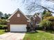 Charming brick home with a well-manicured lawn, two-car garage and mature tree in the front yard at 117 Whitehaven Ln, Cary, NC 27519