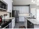 Spacious kitchen boasts stainless steel appliances, granite countertops, and white cabinets at 117 Whitehaven Ln, Cary, NC 27519