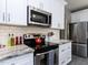 Close up of kitchen featuring stainless steel appliances, white cabinets and subway tile backsplash at 117 Whitehaven Ln, Cary, NC 27519