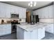 Bright kitchen features white cabinetry, stainless steel appliances, granite counters, and a center island at 117 Whitehaven Ln, Cary, NC 27519