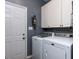 Well-lit laundry room featuring a Maytag washer and dryer and white cabinets at 117 Whitehaven Ln, Cary, NC 27519