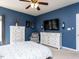 Main bedroom features blue walls, ceiling fan, and dresser at 117 Whitehaven Ln, Cary, NC 27519