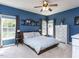 Bright main bedroom with blue walls, ceiling fan, and white dresser at 117 Whitehaven Ln, Cary, NC 27519