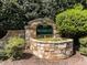 Stone-clad community sign with lush greenery and manicured landscaping at 117 Whitehaven Ln, Cary, NC 27519