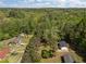 An aerial view of the property showing the home and the surrounding lush greenery and trees at 120 King Charles Rd, Hillsborough, NC 27278