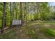 Spacious backyard with mature trees and a storage shed, offering plenty of outdoor space at 120 King Charles Rd, Hillsborough, NC 27278