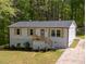 Well-maintained home showcasing new siding, complemented by natural wood accents and landscaping at 120 King Charles Rd, Hillsborough, NC 27278