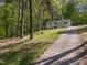 Exterior view of the home showing a long driveway, and surrounding trees at 120 King Charles Rd, Hillsborough, NC 27278