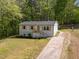 Charming front exterior of home with light siding, shutters, a front porch, and well-manicured lawn at 120 King Charles Rd, Hillsborough, NC 27278