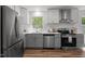 Bright kitchen with stainless steel appliances, quartz countertops, white cabinets, and wood-look flooring at 120 King Charles Rd, Hillsborough, NC 27278