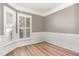 Elegant empty room with hardwood floors, white wainscoting, and plantation shutters at 1206 Areca Way, Durham, NC 27703
