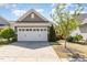 Attached two-car garage with white door, stone accents, and manicured front yard at 1206 Areca Way, Durham, NC 27703