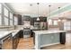 Modern kitchen featuring dark cabinets, stainless steel appliances, and a center island with white countertop at 1206 Areca Way, Durham, NC 27703