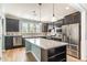 Modern kitchen featuring dark cabinets, stainless steel appliances, and a center island with white countertop at 1206 Areca Way, Durham, NC 27703