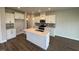 Modern kitchen featuring white cabinetry, stainless steel appliances, and a stylish central island with pendant lighting at 1214 Tredenham Way, Durham, NC 27703