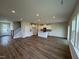Spacious living room and kitchen area with hardwood floors, modern lighting, and staircase to the upper level at 1214 Tredenham Way, Durham, NC 27703