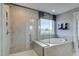 Luxurious bathroom with glass-enclosed shower and relaxing soaking tub by a window at 125 Verona Villa Dr, Burlington, NC 27215