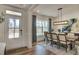 Elegant dining room with modern light fixture, stylish rug, and ample natural light from a large window at 125 Verona Villa Dr, Burlington, NC 27215