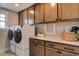Well-equipped laundry room with granite countertops, cabinets and front loading machines at 125 Verona Villa Dr, Burlington, NC 27215