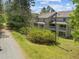 Exterior view of a multi-story condo featuring a balcony and natural surroundings with mature trees and greenery at 128 Schultz St, Chapel Hill, NC 27514