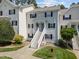 A charming multi-story condo with white siding, dark shutters, and a welcoming front entrance with stairs at 128 Schultz St, Chapel Hill, NC 27514