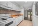A well-lit kitchen with tile flooring, white appliances, wood countertops, and ample cabinet space at 128 Schultz St, Chapel Hill, NC 27514