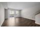 An empty living room featuring laminate flooring, neutral paint, windows, and a sliding glass door at 128 Schultz St, Chapel Hill, NC 27514
