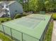 View of a well-maintained and fenced tennis court, surrounded by lush greenery at 128 Schultz St, Chapel Hill, NC 27514
