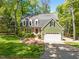 Charming home with a brick facade, green siding, and lush landscaping at 1408 Bridgeport Dr, Raleigh, NC 27615