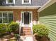 Close-up of the front entrance, showcasing the brick steps and manicured bushes at 1408 Bridgeport Dr, Raleigh, NC 27615