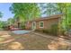 A brick home and a wooden deck with a treed backyard; perfect for outdoor entertaining or relaxation at 1701 Pinedale Dr, Raleigh, NC 27603