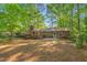 Large backyard with mature trees, a deck, a brick patio, and a birdbath, providing ample outdoor space at 1701 Pinedale Dr, Raleigh, NC 27603