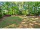 Green backyard space featuring well-maintained grass, trees, and wooden benches, ideal for relaxation and outdoor activities at 1701 Pinedale Dr, Raleigh, NC 27603