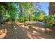 Expansive backyard with mature trees, wooden benches, and landscaped garden areas, perfect for outdoor entertaining at 1701 Pinedale Dr, Raleigh, NC 27603