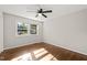 Empty bedroom features hardwood floors, ceiling fan, and window with natural light at 1701 Pinedale Dr, Raleigh, NC 27603