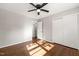 A simple bedroom with hardwood floors, gray walls, closet, and a ceiling fan with light at 1701 Pinedale Dr, Raleigh, NC 27603