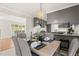 Dining area with modern light fixture, gray chairs, and view into the kitchen at 1701 Pinedale Dr, Raleigh, NC 27603