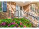Close-up of a brick home's front entrance with pink flowers, and white banister, creating a welcoming entrance at 1701 Pinedale Dr, Raleigh, NC 27603