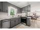 Updated kitchen featuring gray cabinets, granite countertops, and stainless steel appliances at 1701 Pinedale Dr, Raleigh, NC 27603
